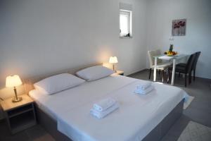a bedroom with a white bed with two towels on it at Villa Aurora in Međugorje