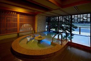 a large room with a pool in the middle of a building at Juhachiro in Gifu
