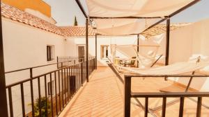 a balcony with a hammock and a house at Alojamiento Nevada in La Zubia