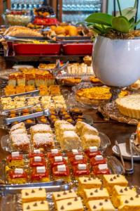 um buffet de sobremesas e tartes numa mesa em Hotel Recanto Maestro em Restinga Sêca