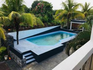 uma piscina no quintal de uma casa em Coral Apartment ( 5 bedroom apartment) em Grand Gaube