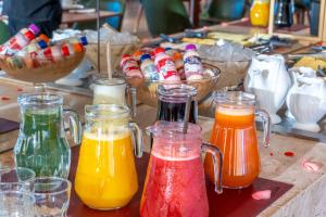 a bunch of different colored liquids in glass jars at Hotel Recanto Business Center in Restinga Sêca