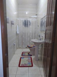een badkamer met een douche, een toilet en een wastafel bij voltamos a funcionar casa da mãe Aparecida in Aparecida