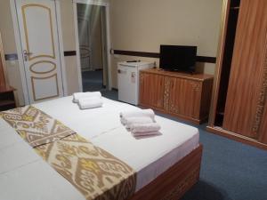 um quarto de hotel com duas camas e uma televisão em Hotel Boutique Al Hayit em Bukhara