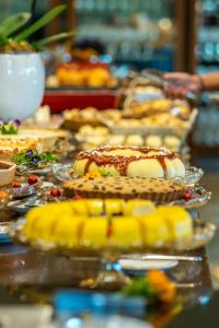 a table with a bunch of desserts on plates at Hotel Recanto Business Center in Restinga Sêca