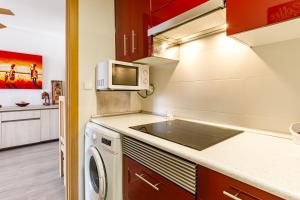 eine Küche mit einer Waschmaschine und einer Mikrowelle in der Unterkunft Stylish apartment with amazing views in Santa Pola