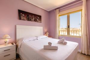 Schlafzimmer mit einem großen weißen Bett und einem Fenster in der Unterkunft Stylish apartment with amazing views in Santa Pola