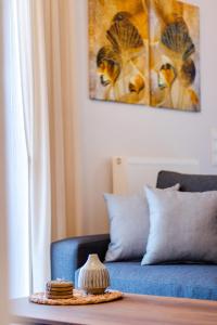- un salon avec un canapé bleu et une table dans l'établissement Agapi's Luxury Apartment, à Pylos