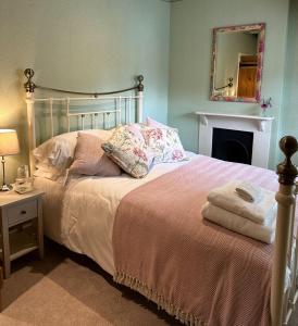 een slaapkamer met een bed, een open haard en een spiegel bij The Old Butchers in Hambleden in Henley on Thames