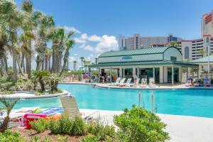 a pool at a resort with palm trees and a building at Long Beach Resort 2-901 - Sunset Beach Club in Panama City Beach