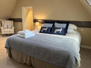 een slaapkamer met een groot bed met blauwe en witte kussens bij The Old Butchers in Hambleden in Henley on Thames