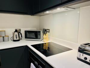 uma cozinha com um micro-ondas e um fogão forno superior em Stunning one bedroom apartment in Old Trafford em Manchester
