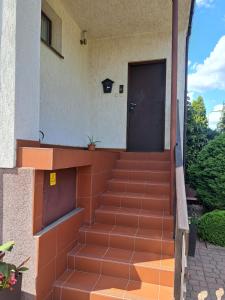 een voordeur van een huis met oranje trappen bij Apartament Matejki in Sierpc