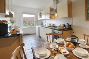 a kitchen with a table with plates and food on it at Castle Cottage, Wadhurst in Wadhurst