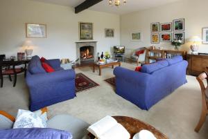 a living room with blue couches and a fireplace at Castle Cottage, Wadhurst in Wadhurst