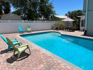 a swimming pool with two chairs next to a fence at Poolside Paradise & Beach Bound in Seminole