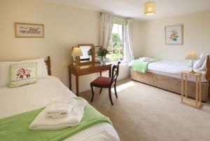 a hotel room with two beds and a desk and a window at Castle Cottage, Wadhurst in Wadhurst