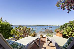 a patio with chairs and a table and a view of the water at Villa Lydia in Faro
