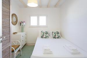 a white bedroom with a bed and a window at Villa Lydia in Faro