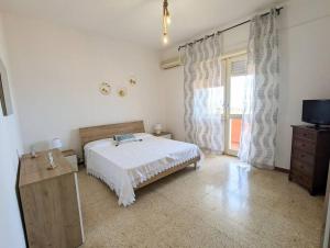a bedroom with a bed and a television and a window at Villa Mariuccia in Nebida