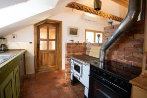 a kitchen with a stove and a brick wall at Horse Farm Holiday Pr' Kolenc in Zgornje Gorje