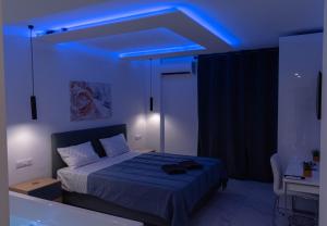 een slaapkamer met een bed met een blauw licht bij Athens Jacuzzi apartment in Athene