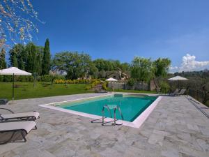 a swimming pool in a yard with chairs and umbrellas at Cosy holiday home in Selci with swimming pool in Selci