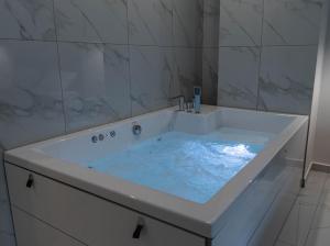 een badkamer met een bad met blauw water bij Athens Jacuzzi apartment in Athene +17 foto's