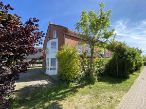 a brick house with a tree in the yard at Marina in Schönberger Strand