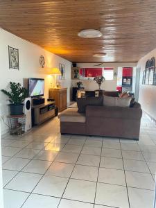 a living room with a couch and a tv at Les tourterelles in Saint-Joseph