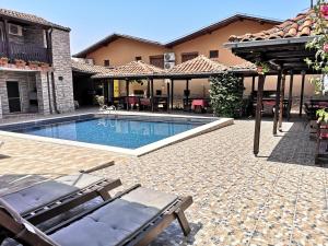 a swimming pool with chairs and a house at Bali Petrich in Petrich