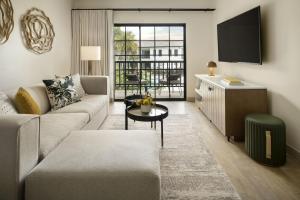 a living room with a couch and a tv at The Steward, Santa Barbara, a Tribute Portfolio Hotel in Santa Barbara