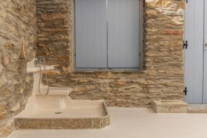 Baño de piedra con lavabo y ventana en PG Houses in Kalloni Village - PHouse en Kalloni Tinou