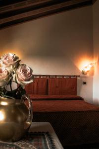 a room with a couch with roses in a vase at Hotel Liberty in Spresiano