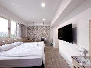 a bedroom with a large bed and a flat screen tv at 夢境旅-智能自助旅店 in Zhongli