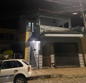 una macchina bianca parcheggiata di fronte a una casa di notte di Casa Grande para Família e Amigos a São Lourenço