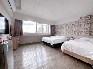 Habitación de hotel con 2 camas y TV de pantalla plana. en Meng Jing Hotel en Zhongli
