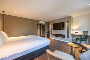 Habitación de hotel con cama grande y TV en Boutique Hotel Corona en La Haya