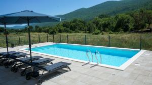 una piscina con dos tumbonas y una sombrilla en Villa Edvard, en Poljica
