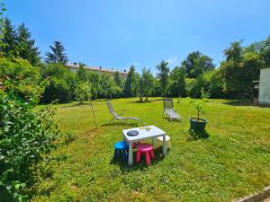 una mesa pequeña y sillas en un campo de hierba en House in center of Gospic with big garden, en Gospić