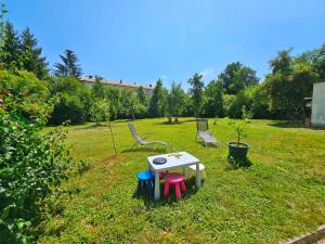 a small table and chairs in a grass field at House in center of Gospic with big garden in Gospić