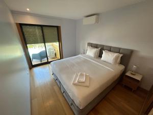 a bedroom with a large white bed with a window at Paraíso da Ria Formosa in Faro