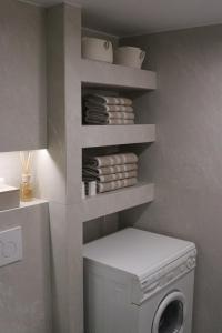 a laundry room with a washing machine and shelves at Nonta's Luxury Home in Megalochori