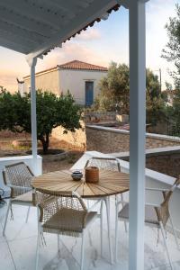 Une table et des chaises en bois sont disponibles sur la terrasse. dans l'établissement Nonta's Luxury Home, à Megalochori