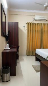 a bedroom with a bed and a desk and a mirror at Krishna Kunja " A Quiet & Peaceful Stay " in Kolkata