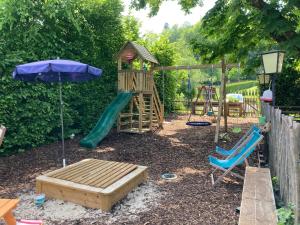 a playground with a slide and an umbrella at Hinkelshof in Körperich