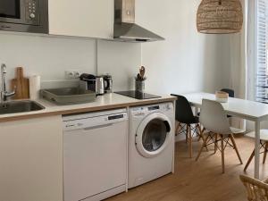 una cucina con lavatrice e tavolo di T2 climatisé dans l’hyper-centre de Marseille a Marsiglia