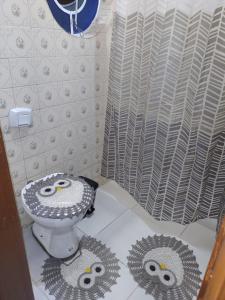 a bathroom with a toilet with eyes on the floor at Casa da Mãe próximo a Basílica in Aparecida +18 photos