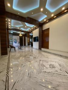 a lobby with a marble floor and ceiling with lights at Krishna Kunja " A Quiet & Peaceful Stay " in Kolkata