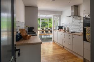 a kitchen with white cabinets and a counter top at Angel Cottage - 5 mins drive to Alton Towers! in Alton
